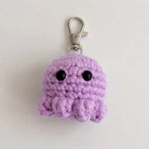 Handmade crochet octopus keychain in lavender on a white background