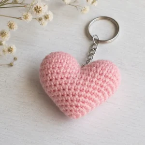 Close-up view of the handmade stitches on a pink crochet heart keychain